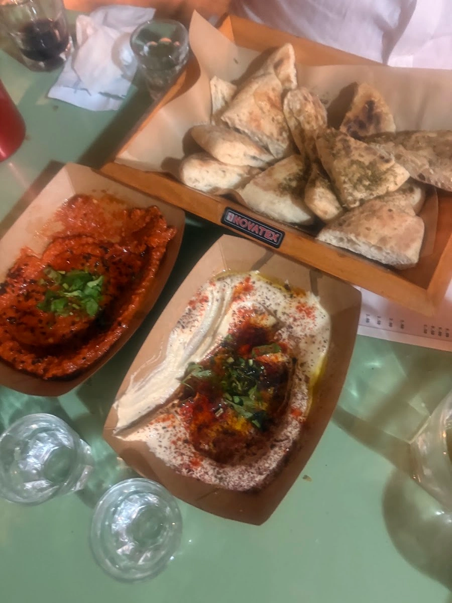 Fresh pita with hummus and muhammara on a table at Sumac