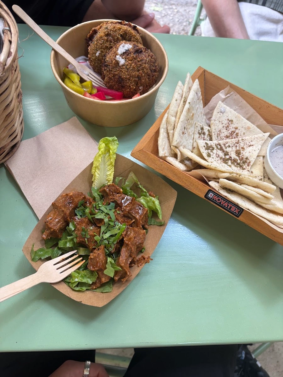 Falafel, pita bread, pickles, and a dressed salad served at Sumac