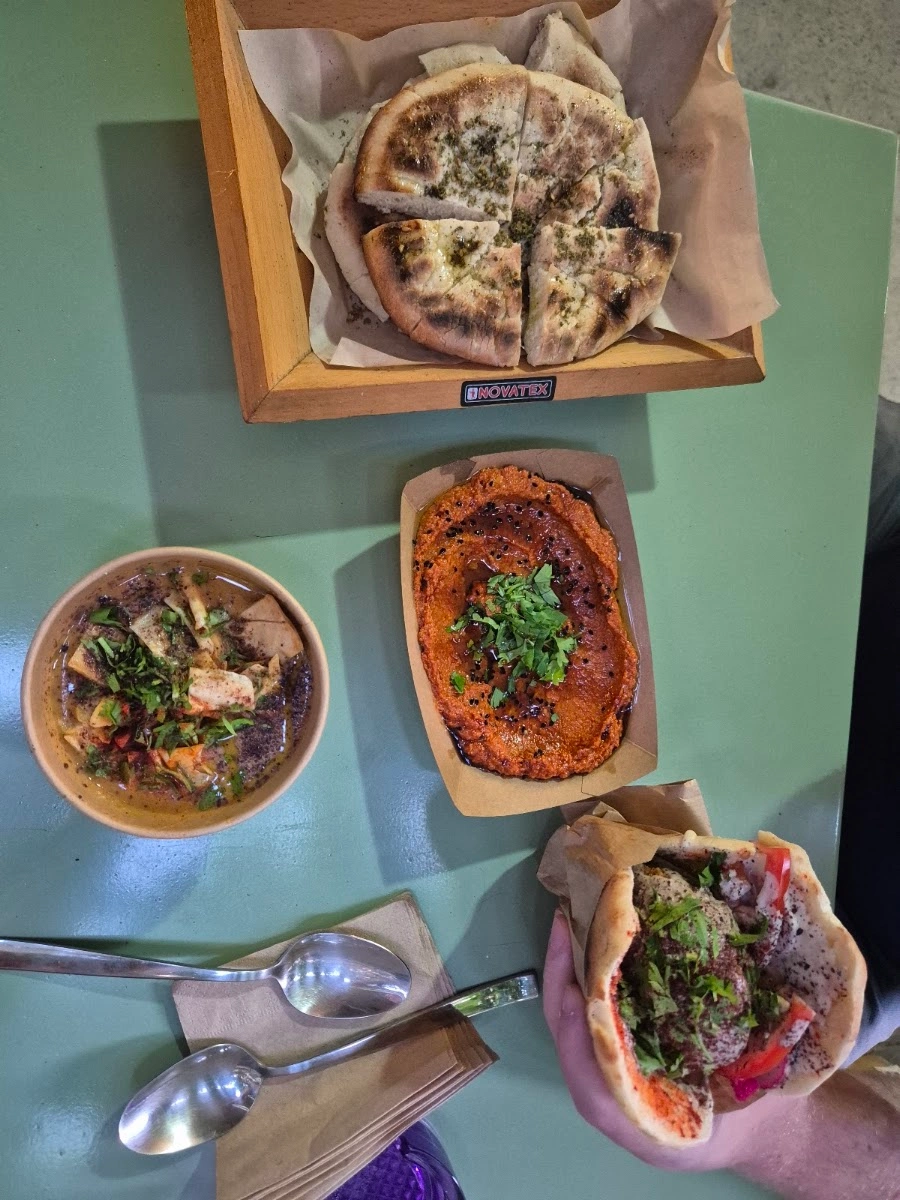 A spread of pita, lentil soup, muhammara, and a falafel wrap at Sumac
